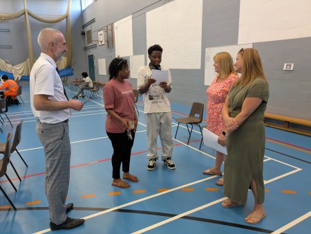 Student and parent talking with teachers about their results
